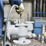 A worker uses high air pressure to blow away small debris before assembly. Image courtesy Shutterstock